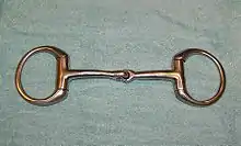 A metal horse bit with a jointed mouthpiece and a ring on either side