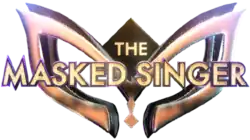 The words "The Masked Singer" in a gold-colored, capitalized typeface appearing in front of a 3D mask design