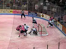 South Carolina Stingrays (in pink jerseys) battle the Toledo Walleye (in white jerseys) for control of the puck in front of the Walleye goaltender. The ice is dyed pink for Pink in the Rink 2010.