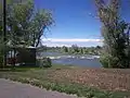 A gazebo on the greenbelt in Shelley, ID overlooks the Snake River as it flows over some rocks.  This gazebo was destroyed in 2009.
