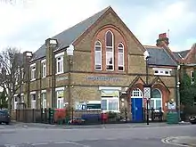 A yellow brick building of very similar appearance to the church